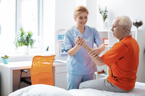 Joyful positive woman massaging her patients hand - 写真・画像