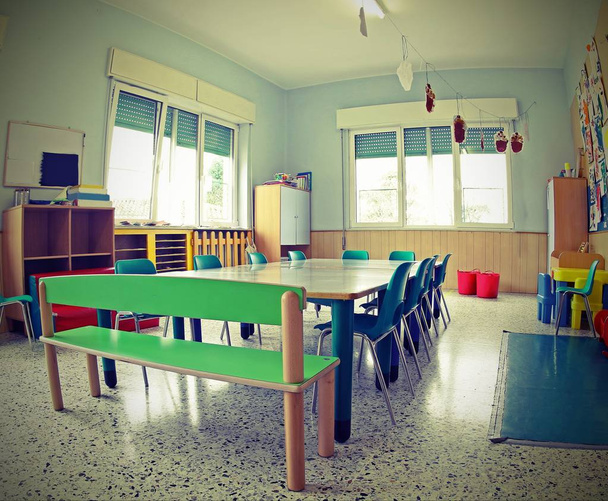 sillas pequeñas y mesas bajas dentro de un aula escolar con vinta
 - Foto, imagen