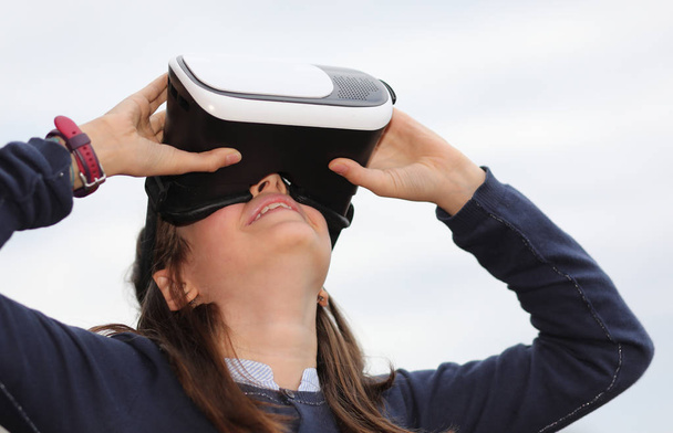 kaukázusi lány és a virtuális valóság headset fehér háttér - Fotó, kép