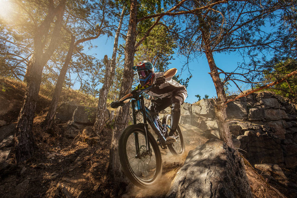 Maastopyöräilijä metsäpolulla. Mies pyöräilijä ratsastaa kivellä
 - Valokuva, kuva