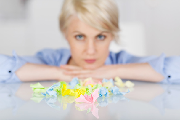 Female Executive With Colorful Crumpled Paper Balls At Desk - Foto, Bild