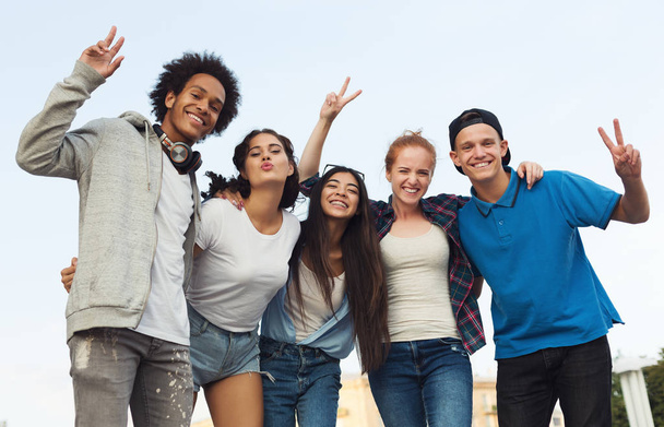 Gruppe glücklicher Teenager umarmt und lächelt in die Kamera - Foto, Bild