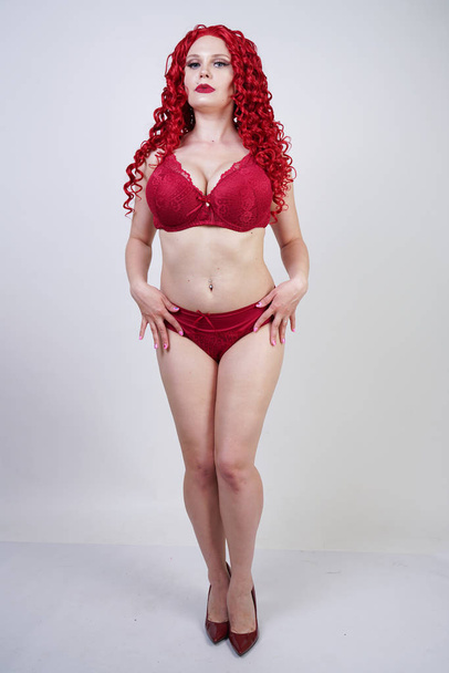 sexy hot curvy girl with red curly hair wearing lace sexy lingerie and high heels in the studio - Fotoğraf, Görsel