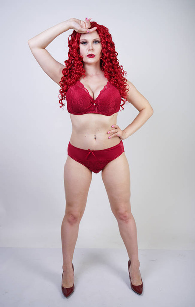 Seksowna gorąca krzywego dziewczyna z czerwonym kręconymi włosami nosi koronkę seksowną bieliznę i wysokie obcasy w studiu - Zdjęcie, obraz