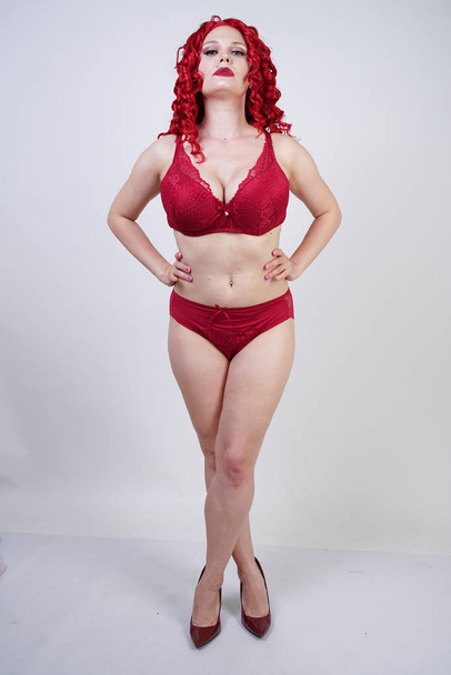 sexy quente curvy menina com cabelo encaracolado vermelho vestindo rendas lingerie sexy e saltos altos no estúdio
 - Foto, Imagem