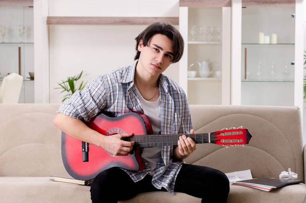 Young man with guitar at home - Photo, Image