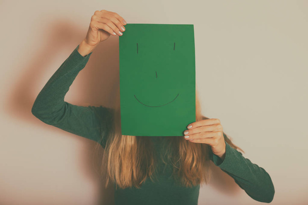 Kobieta ze szczęśliwą twarzą na papierze stojąca przed ścianą.Toned image. - Zdjęcie, obraz