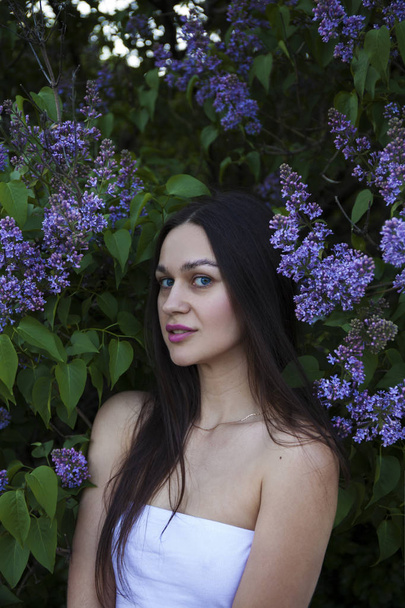 Portrait of a young beautiful brunette woman on a lilac backgrou - Φωτογραφία, εικόνα