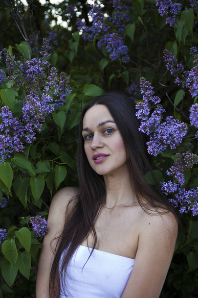 Portrait of a young beautiful brunette woman on a lilac backgrou - Fotoğraf, Görsel