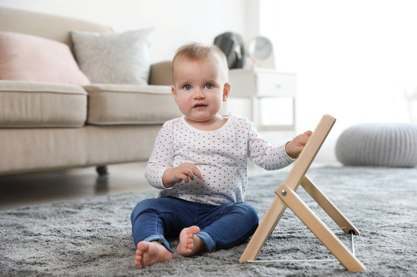 Cute baby playing with abacus on floor in room - Fotó, kép