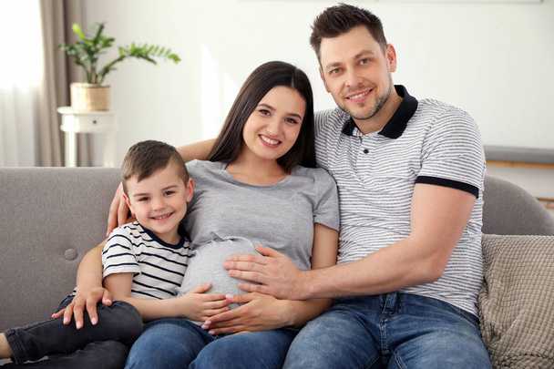 Padre, figlio e madre incinta passano del tempo insieme sul divano di casa. Tempo di famiglia
 - Foto, immagini