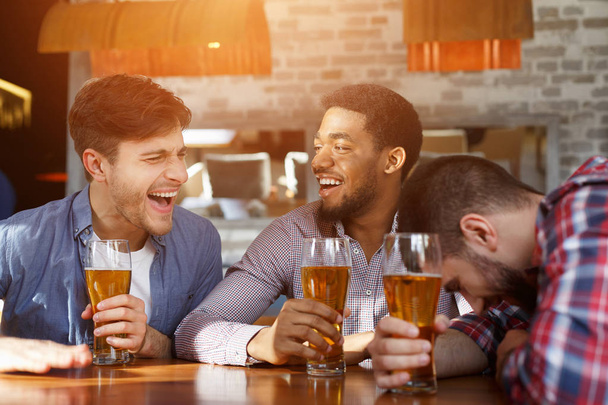 Διαφορετικοί φίλοι πίνοντας μπύρα και μιλώντας στο μπαρ - Φωτογραφία, εικόνα