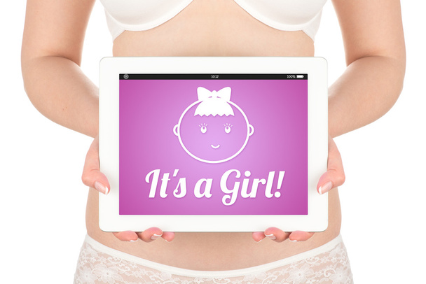 μια έγκυος γυναίκα κρατά έναν υπολογιστή δισκίο με τις ειδήσεις για κορίτσι φύλου του παιδιού. - Φωτογραφία, εικόνα