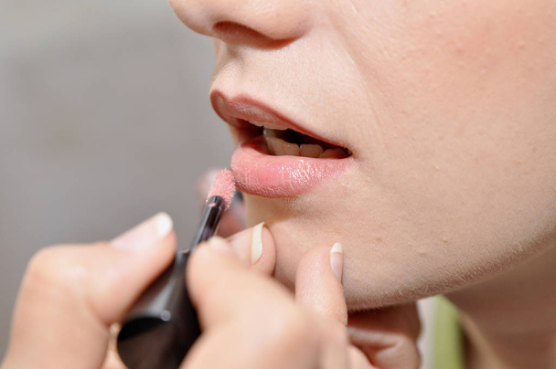 Close-up. Meisje schildert haar lippen - Foto, afbeelding