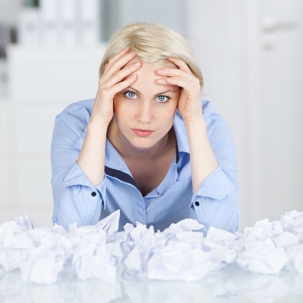 Tired executive With Crumpled Paper Balls At Desk - Fotó, kép