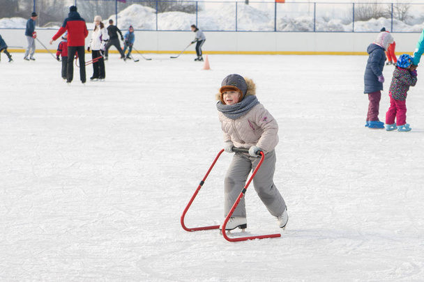 Ice skating with child support device - Foto, afbeelding