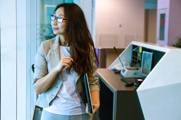 jong aziatisch vrouw in kantoor holding folder, glimlachen, portret. - Foto, afbeelding