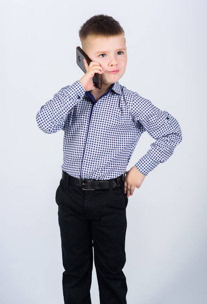 Mobile communication. Modern gadget. Small businessman. Upbringing and development. Little boy formal clothes call mobile phone. Cute boy hold smartphone. Mobile conversation. Business school - Valokuva, kuva