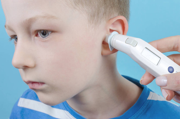 taking temperature with ear thermometer by child - Foto, immagini