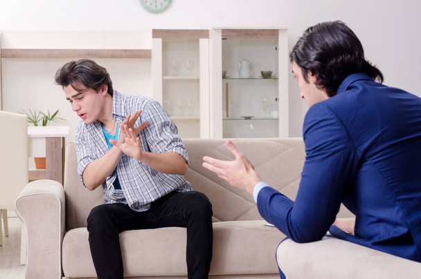 Jovem paciente do sexo masculino discutindo com psicólogo problema pessoal - Foto, Imagem