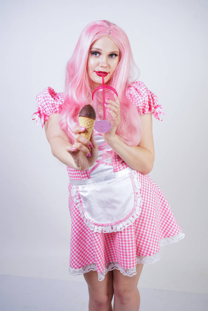 erotic caucasian chubby girl in pink plaid doll dress holds delicious summer ice cream and sexy flirts on white studio background - Φωτογραφία, εικόνα