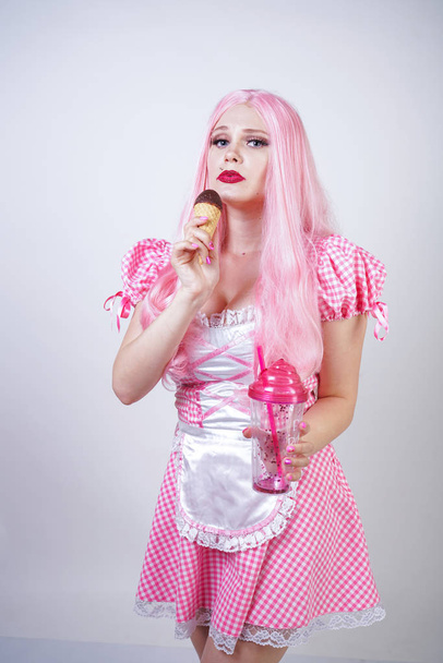эротическая кавказская пухленькая девушка в розовом клетчатом платье держит вкусное летнее мороженое и сексуальные флирты на белом фоне студии
 - Фото, изображение