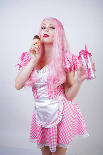 erótico caucasiano gordinha menina no vestido de boneca xadrez rosa detém delicioso sorvete de verão e flertes sensuais no fundo do estúdio branco
 - Foto, Imagem