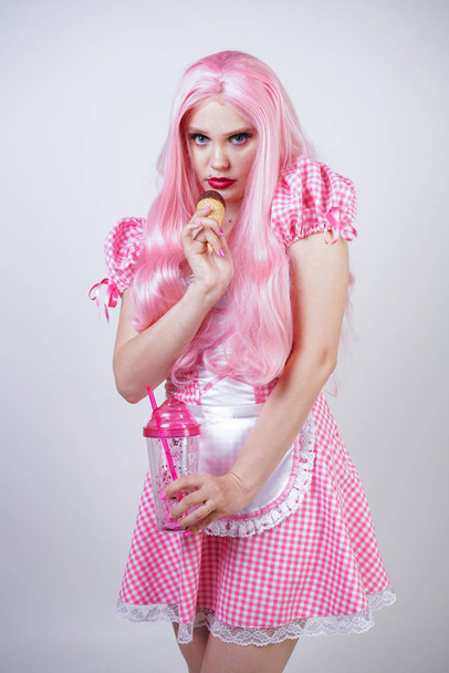 erotic caucasian chubby girl in pink plaid doll dress holds delicious summer ice cream and sexy flirts on white studio background - Photo, Image