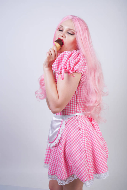 эротическая кавказская пухленькая девушка в розовом клетчатом платье держит вкусное летнее мороженое и сексуальные флирты на белом фоне студии
 - Фото, изображение