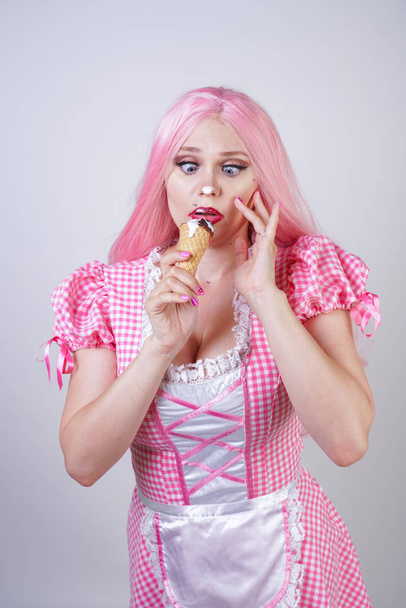 erotische kaukasische mollige Mädchen in rosa karierten Puppenkleid hält köstliches Sommereis und sexy Flirts auf weißem Studiohintergrund - Foto, Bild