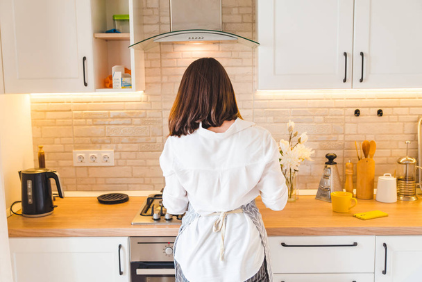view from behind woman on kitchen cooking - Foto, Imagem