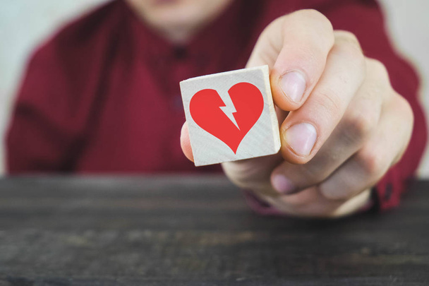 Ręka umieszczenie kostki z czerwonym symbolem serca, który jest przeciwny do czarnych złamanych serc na innych drewnianych kostek - Zdjęcie, obraz