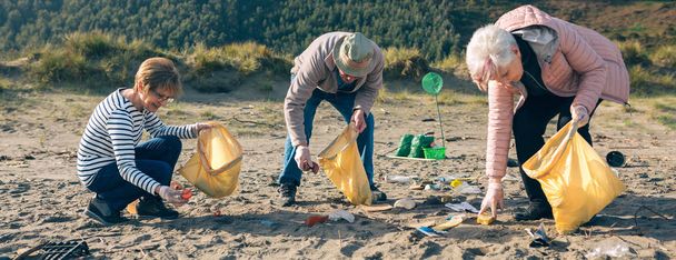 Ältere Freiwillige säubern den Strand - Foto, Bild
