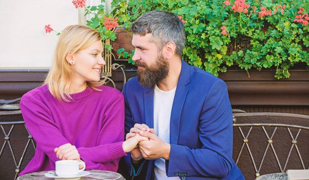 Morning vibes in cafe. Couple in love on romantic date. Brutal bearded hipster and girl drink coffee. First meet of girl and mature man. woman and man with beard relax in cafe. Morning coffee - Photo, Image