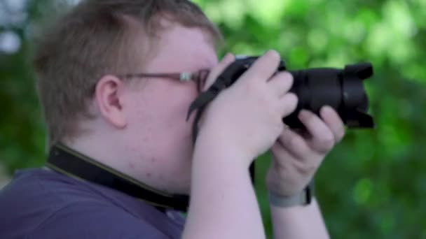 Nuori mies ottaa kuvia puistossa
 - Materiaali, video