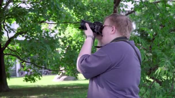 Young man takes pictures in the park - Footage, Video