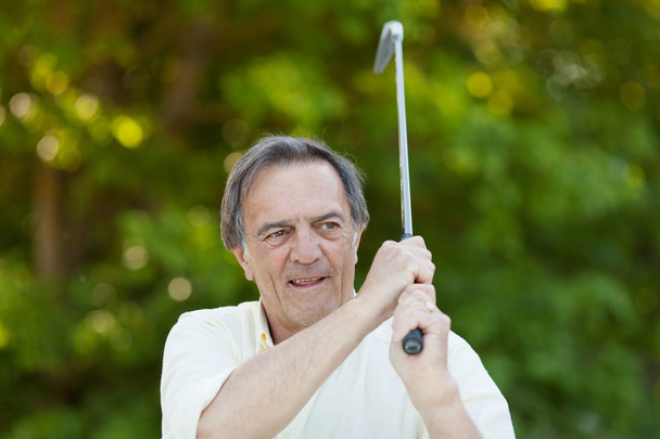Elderly man with golf stick in action - Foto, Imagen