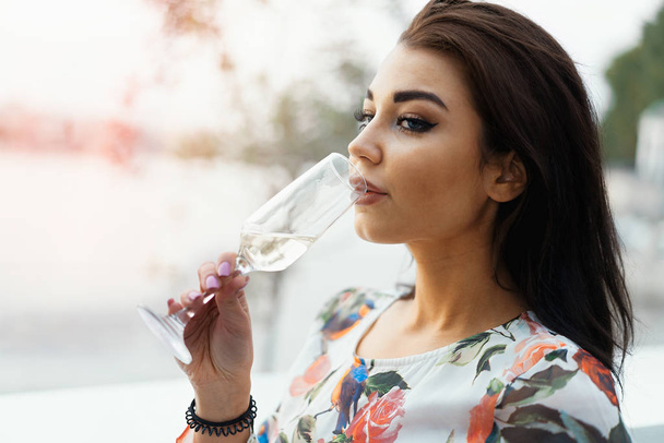 Young beautiful woman drinking champagne at the beach in street cafe. - Foto, afbeelding