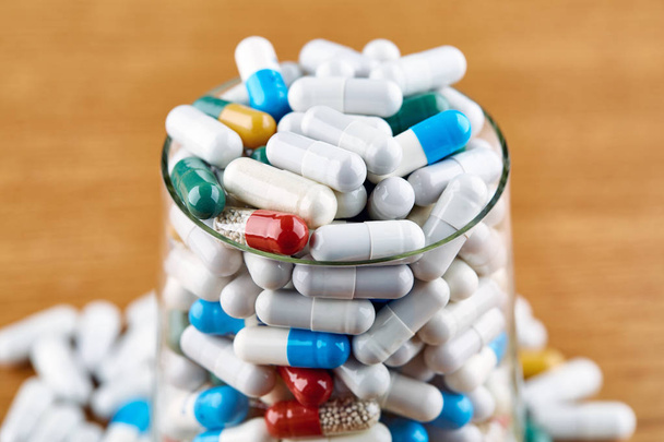 Molte pillole colorate in vetro trasparente su sfondo di legno
 - Foto, immagini