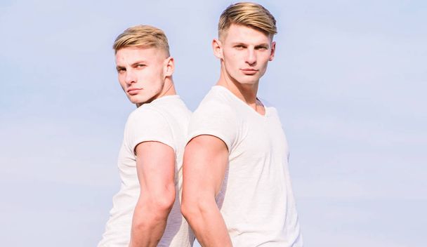 Men twins brothers muscular guys in white shirts sky background. Brotherhood concept. Benefits of having twin brother. Friendship of brothers. Benefits and drawbacks of having identical twin brother - Zdjęcie, obraz