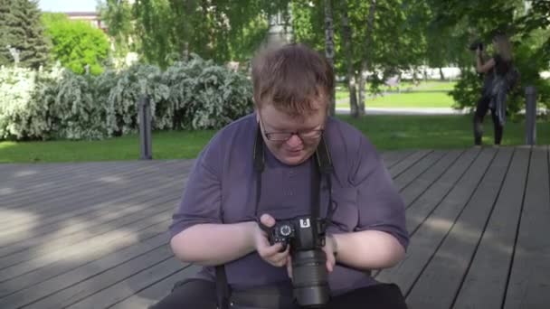 若い男が公園で写真を撮る - 映像、動画