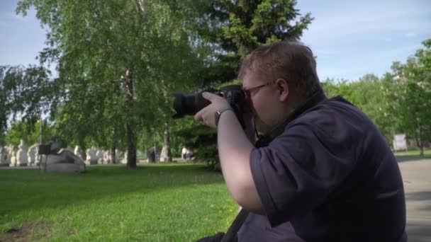 Młody człowiek robi zdjęcia w parku - Materiał filmowy, wideo