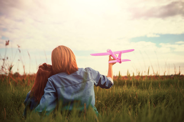 Unrecognizable mother and daughter playing with plane in meadow - Foto, Imagem