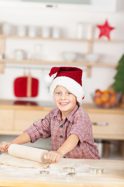 Smiling young boy with santa hat baking - Zdjęcie, obraz