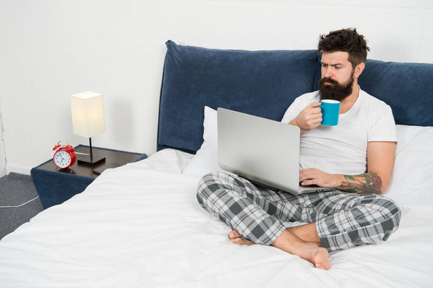 Sleeping at working place. asleep and awake. energy and tiredness. businessman with computer. bearded man hipster work on laptop. brutal sleepy man in bedroom. mature male drink coffee - Foto, Imagem