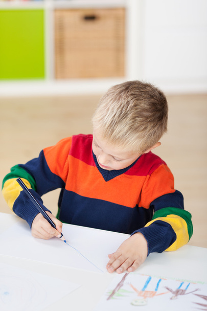 Boy Drawing On Paper At Table - 写真・画像