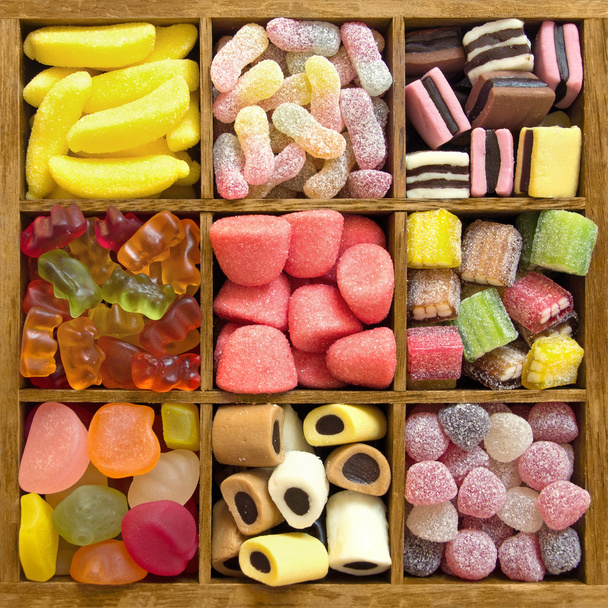 Assorted candy in a wooden box - Фото, зображення