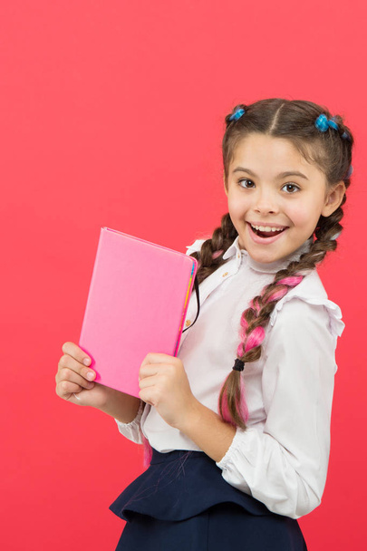 Kid school uniform hold book. Stationery admirer. Schoolgirl show notepad. School supplies concept. School stationery. Buy cute stationery for fun studying. Girls famous for obsession with stationery - Foto, Imagem