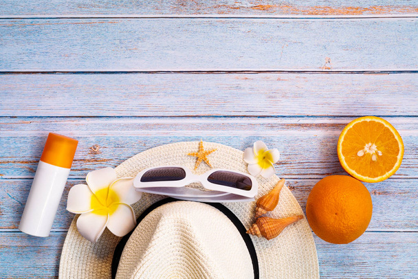 Beautiful summer holiday, Beach accessories, sunglasses, hat, sunblock and orange on wooden backgrounds - Photo, Image