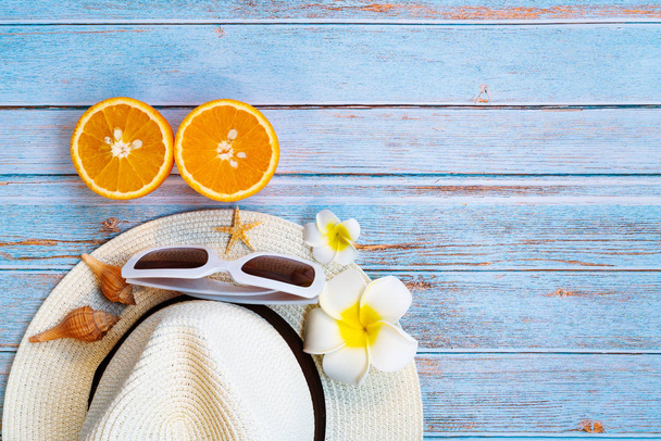 Krásná letní dovolená, plážové doplňky, sluneční brýle, klobouk a oranžová na dřevěném pozadí - Fotografie, Obrázek
